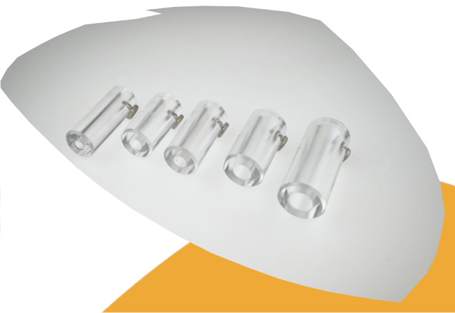 Five clear cylindrical plastic or glass clips arranged in a row on a white background with a yellow-orange shape underneath.