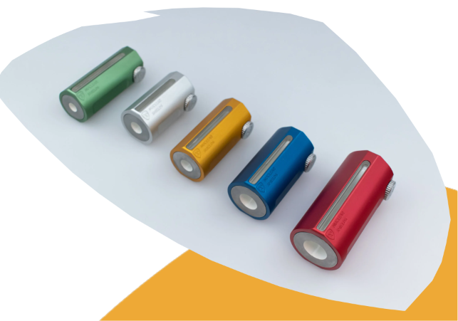 Five slim cylindrical electronic devices in green, silver, gold, blue, and red, arranged diagonally on a white curved panel with an orange accent shape behind them.